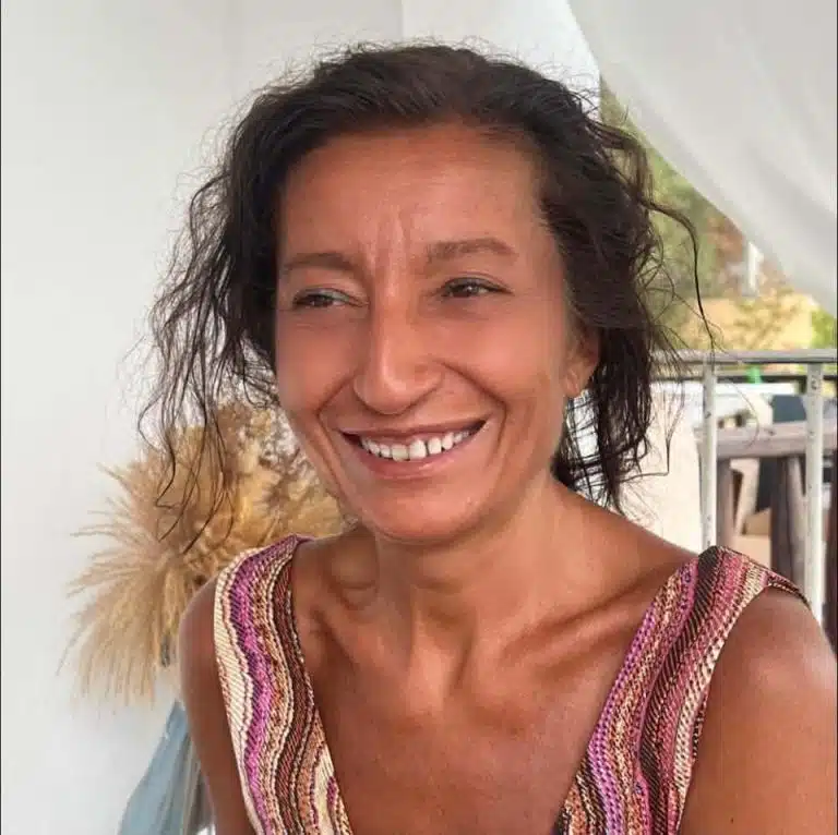 Elena Sanjust di Teulada sorride, di profilo, con una veste a righe colorate
